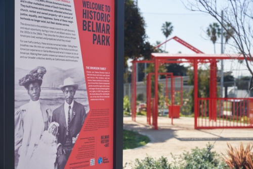 Welcome to Historic Belmar Park panel with artwork in the distance.